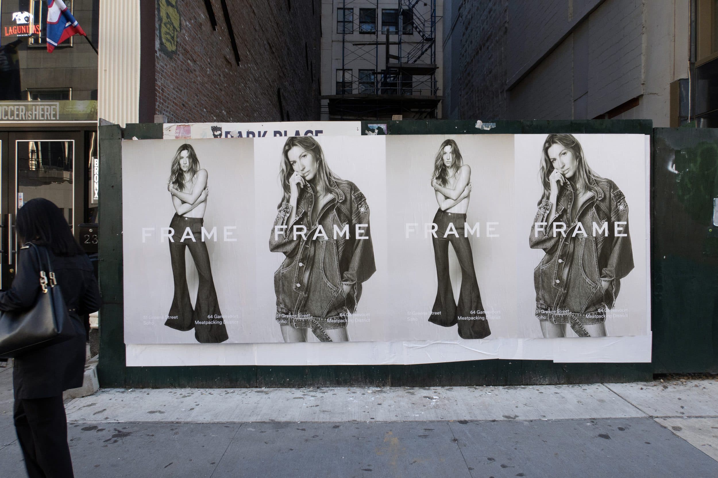 FRAME — Gisele wheatpaste posters across a construction hoarding
