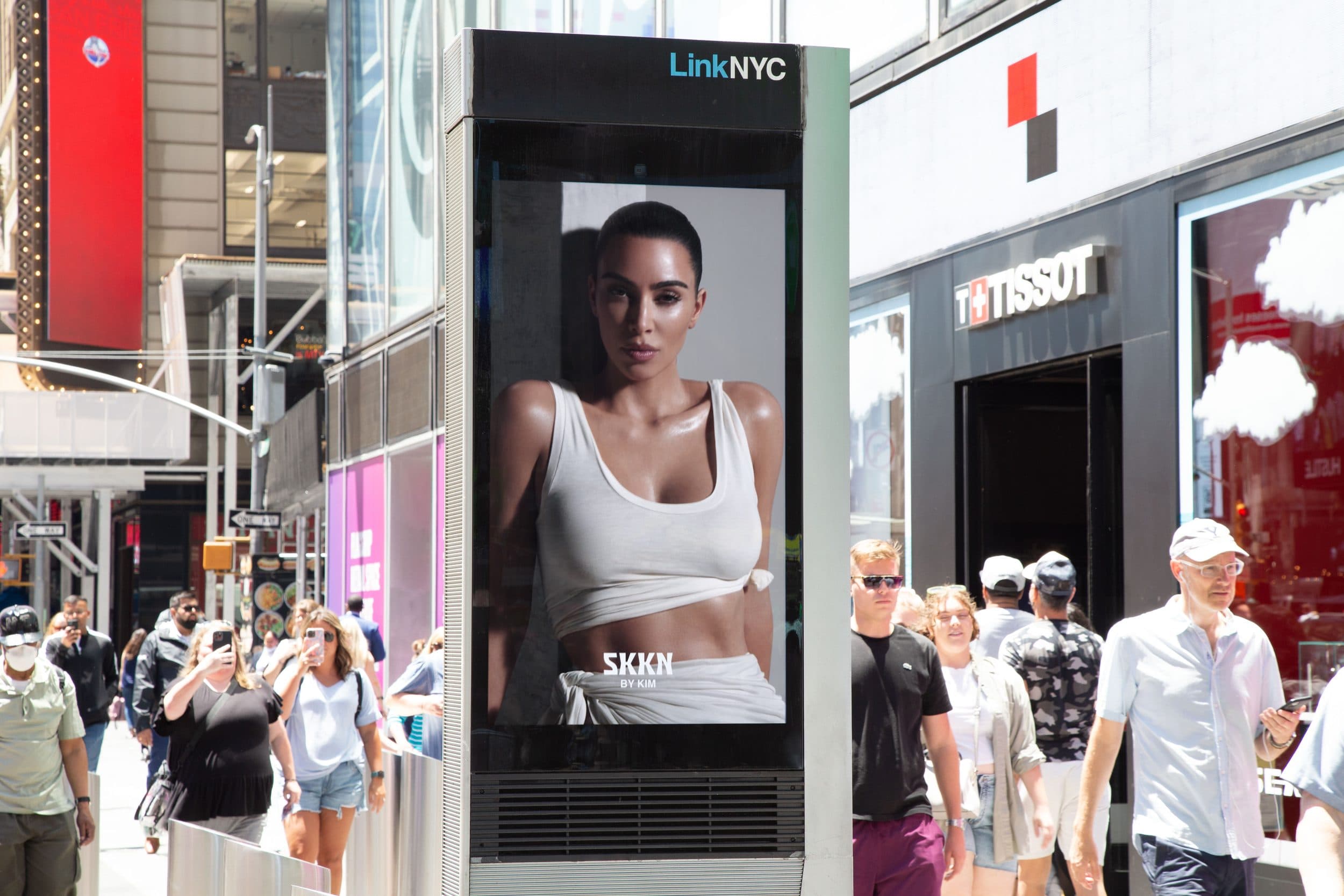 SKKN by Kim — LinkNYC digital street kiosk on a crowded sidewalk